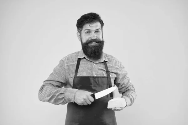 Produit gastronomique. Produits laitiers dérivés du lait. Achats en ligne. Alimentation et nutrition. Concept de vendeur. Fromagerie. Un barbu au tablier tient du fromage. Profession du personnel du magasin. Acheter du fromage — Photo