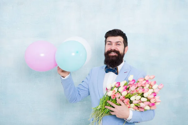 Δώρο για σύζυγο. Ο τύπος με τα αερόστατα. Πάρτι γενεθλίων. Γενειοφόρος χίπστερ με μπουκέτο λουλουδιών. Ημέρα των γυναικών. Γενειοφόρος με τουλίπες. Ανοιξιάτικο πάρτι. Έκπληξη κόμμα ρομαντικές ιδέες πρόταση — Φωτογραφία Αρχείου