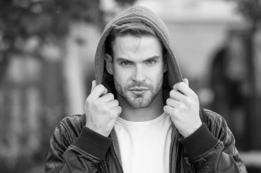 Sonbahar soğuğu için moda. Yakışıklı adam kapüşonlu moda ceketi giyiyor. Sonbahar tarzı açık havada genç bir adam. Erkek modası eğilimleri ve mevsimlik tarzları. Sonbahar için kıyafet dolabı.