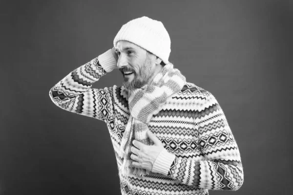 Tak przytulnie. Kolekcja zimowa. Dojrzały mężczyzna cieszy się ciepłem komfortu. Zimne warunki. Przystojny brodaty facet w czerwonym tle w kapeluszu. Zimowy sweter. Dziane dodatki. Zimowy styl pogody — Zdjęcie stockowe