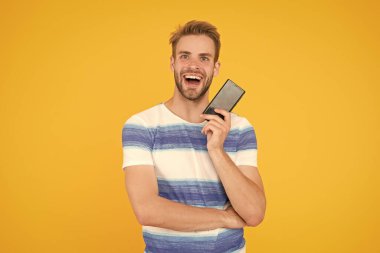 Dijital dünyaya katıl. Uygulamayı indir. Adam akıllı telefonu tutuyor. Adam akıllı telefon ekranını gösteren mutlu bir gülücük. Akıllı telefon için başvuru yapmayı dene. Mobil iletişim. Mobil operatör tarifesi