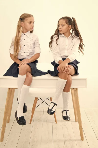 Porque estás triste? Estudantes arrumado penteado relaxante ter descanso. Uniforme escolar. Clube da escola. Pequenas alunas colegas de turma crianças amigáveis. As alunas amigas sentam-se na secretária. Melhores amigos relaxante — Fotografia de Stock