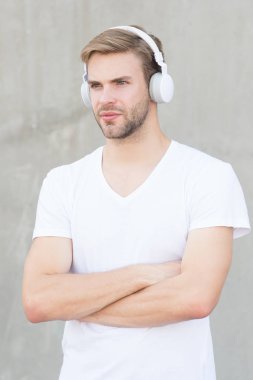 Modern teknoloji. Modern ve çağdaş müzik. Hobi eğlencesi. Katlanabilir Stereo kulaklıklar. Gürültü Azaltma. Kablosuz kulaklık. Yakışıklı adam kulaklık takıyor gri arka plan. Modern müziği dinle.