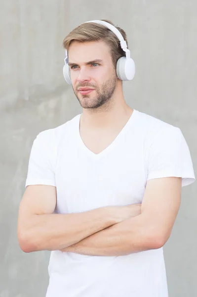 Tecnologia moderna. Música moderna e contemporânea. Lazer de passatempo. Auriculares estéreo dobráveis. Redução de ruído. Fone de ouvido sem fio. Um tipo bonito usa auscultadores fundo cinzento. Homem ouvir música moderna — Fotografia de Stock