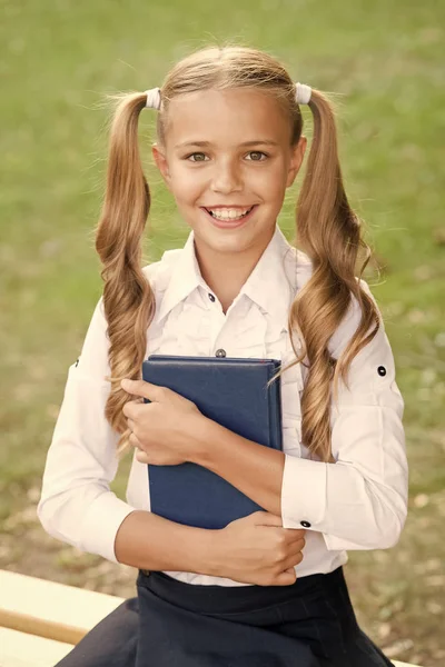 Estudia lenguaje. Concepto de educación escolar. Lindo pequeño ratón de biblioteca. Día del conocimiento. Listos para las lecciones. Estudiante de secundaria. Lindo niño sonriente sostiene libro. Adorable niña estudiante de la escuela — Foto de Stock