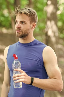 Güç dengesi. Vücut sıvısına dikkat et. Spor ve sağlık. Spor giyim bölümündeki adam su içiyor. Antrenmandan sonra vitamin içeceği. Su şişeli atletik adam. Sporcu parktaki eğitimden sonra su içer