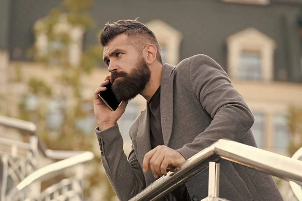 Mobiel is levensstijl. Projectmanager maakt gebruik van mobiele apparaat outdoor. Een man met een baard praat op een mobiele telefoon. Mobiele zakelijke communicatie. Het moderne leven. Nieuwe technologie — Stockfoto