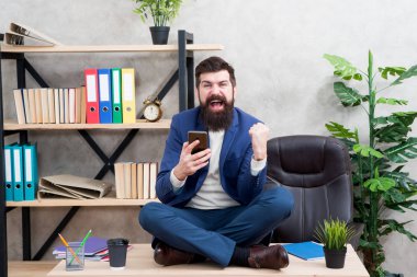 İnternette rahatla. Kişisel bakım. Rahatlama teknikleri. Zihinsel refah ve rahatlama. Adam sakallı yönetici resmi takım elbise lotus pozu rahatlatıcı. Uygulama akıllı telefonu. Oyun oynayın. Haberler iyi. Sosyal ağlar