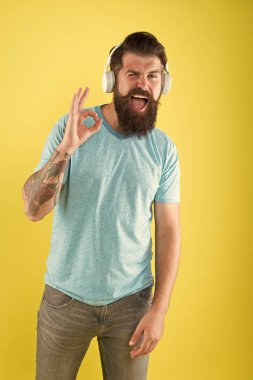 Modern kablosuz kulaklıklar kullanarak mutlu hipster. Sakallı adam müzik kablosuz Gadget dinlerken. Kablosuz kulaklıklar temiz ses sunmak için tasarlanmıştır. Özgürlük kablosuz teklifler gidiyor benzersiz