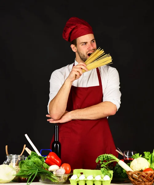 Koch mit hungrigem Gesicht hält Spaghetti in der Hand — Stockfoto