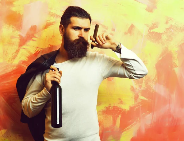 Brutalny, biały hipster trzymający butelkę i palący cygaro — Zdjęcie stockowe