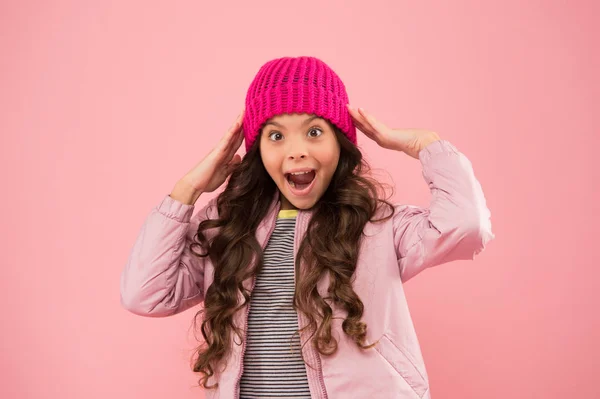 Να περάσεις καλά. εποχιακή μόδα για τα παιδιά. μικρό όμορφο ροζ τοίχο. Κοριτσάκι μπουφάν και πλεκτό καπέλο. υγειονομική περίθαλψη σε κρύο καιρό. καλή διάθεση για κάθε καιρό. χαρούμενο παιδί με ζεστά χειμωνιάτικα ρούχα — Φωτογραφία Αρχείου