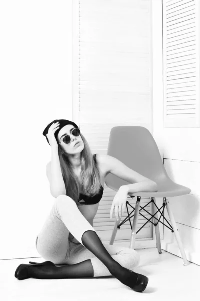 Mujer bastante sexy en gafas de sol, sujetador, sombrero en silla naranja —  Fotos de Stock