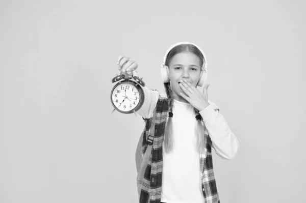 Classes schedule. Schoolgirl hold alarm clock yellow background. School timing concept. Beginning of lessons. Time go school. School time. Happy girl hold alarm clock counting minutes. Knowledge day — Stock Photo, Image