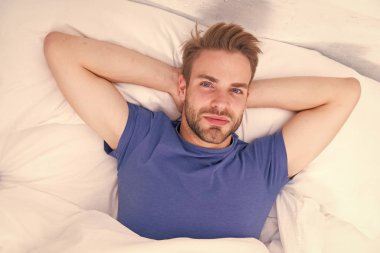 Güne düzenli olarak başlıyor. Yakışıklı adam sabah rutini için uyandı. Bakım rutininden önce yatakta yatan seksi adam. Kutsal rutin adam her sabah...