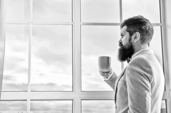 His big day. Wedding morning concept. Wedding day. Groom bearded hipster man wear blue tuxedo and bow tie. Man stand at window nervous about wedding. Life choices and expectations. But first coffee