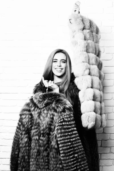 Усміхнена модна жінка в хутрі на білій цегляній стіні студійний фон — стокове фото
