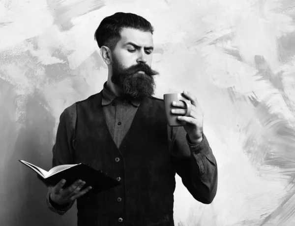 Bearded brutal caucasian hipster with coffee cup and black notebook — Stock Photo, Image
