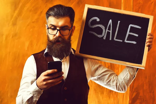 Hombre barbudo, brutal hipster caucásico con inscripción de venta de teléfonos inteligentes —  Fotos de Stock