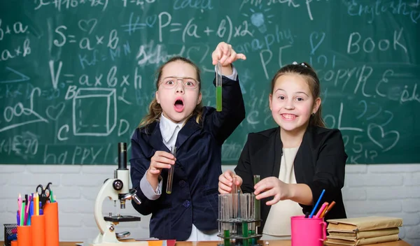 Kimyasal reaksiyon gösterirken dikkatli olun. Temel kimya bilgisi. Kızlar kimya okuyor. Kimya çalışmasını ilginç hale getir. Mikroskop ve test tüpleri masada. Eğitim deneyi konsepti — Stok fotoğraf