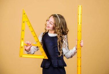Öğrenci geometri okuyor. Çocuk okulu üniforması cetveli tutar. Geometri dersi. Eğitim ve okul konsepti. Zekice ve zekice bir fikir. Boyut ve boyut. Büyük cetvelli tatlı kız.