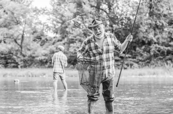 Fiskare med metspö. Aktivitet och hobby. Fiske sötvatten sjö damm flod. Skäggiga män som fångar fisk. Gammal man med vänskapsfiske. Sommarsemester. Glada glada människor. Huvudbetare — Stockfoto