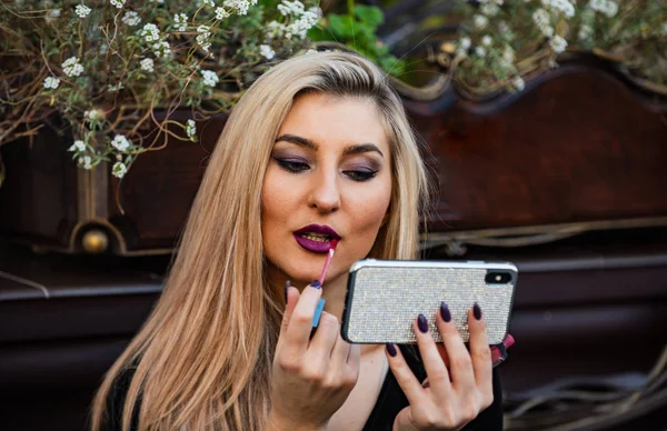 Smartphone mirror. Cosmetics review channel. Beauty blogger concept. Apply makeup. Girl watching makeup tutorial video. Lipstick on lips. Cosmetics and makeup. Get ready for date. Always looking good