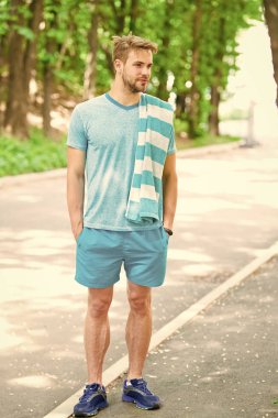 Yakışıklı atlet. Sabah eğitimi için motive. Havlu doğa arka plan ile Adam atlet. Atletik adam rahatlatıcı mola. Atlet yorucu egzersizler sırasında mola alır. Koşucu egzersiz açık