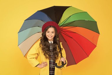 Yağmur yağmasını bekliyorum. Küçük çocuk şemsiyeyi açık tut. Yağmur aksesuarı. Moda aksesuarlı küçük bir kız. Yağmurlu sonbahar mevsimi için suç ortağı. Onu korumak için mükemmel bir aksesuar.