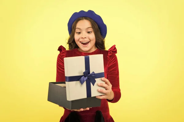 Shopping happiness. surprised small girl with present box. small girl hold holiday gift. happy birthday. boxing day. parisian girl in french beret go shopping. autumn fashion. school fall season