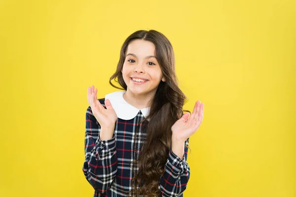 Just happy. Small girl classy checkered dress. Child long curly hair. Happy schoolgirl stylish uniform. Childhood concept. Kids psychology. Happy smiling kid portrait. Emotions emotional expression — Stock Photo, Image