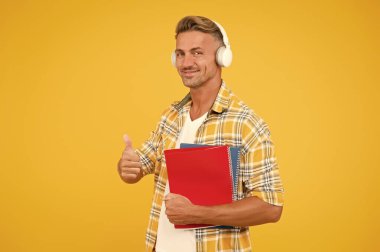 Başka bir çalışma şekli. İngilizce öğreniyorum. Eğitim teknolojisi. Çalış. Ses kitabı konsepti. Dünya çapında bilgi erişimi. Ses kütüphanesi. Yakışıklı üniversite öğrencisi kulaklıkları. Dil çalış