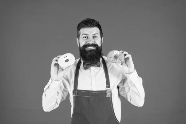 Entrega de donuts. padeiro qualificado com donut. Cozinheiro hipster engraçado donut. tentação enquanto dieta. padaria de cozinha masculina. Homem barbudo com avental de chef. Empregado brutal na cozinha. maduro homem vermelho fundo — Fotografia de Stock