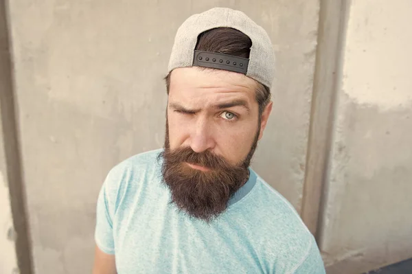 Behandel je snor vandaag. Serieuze man met een lange baard en snor op een grijze muur. Brute hipster met getextureerd snorharen op ongeschoren gezicht. Baard man met stijlvolle snor vorm — Stockfoto