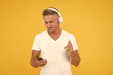 Kablosuz eşittir özgürlük. Müzik aboneliği. Modern kulaklıklar ve akıllı telefonlar. Dinleme konsepti. En iyi müzik uygulamaları. Guy modern kullanıcı mobil uygulaması. Favori müzik listesi