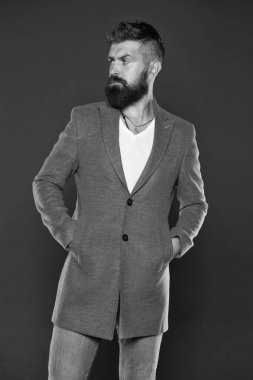 Yoğunlaşmış ciddi bir adam. Vahşi görünümlü beyaz bir adam. Sakallı, bıyıklı, sakallı, sakalsız, vahşi yüzlü bir adam. Sıradan kıyafetler giyen vahşi bir hippi. Rahat, sade bir ceket.