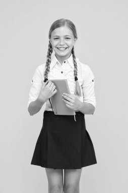 Harika bir kitap, harika bilgiler. Mutlu küçük kız sarı arka plan hakkında bilgi ile kitap tutan. Küçük çocuk kütüphane kitabından bilgi alıyor. Okul bilgileri