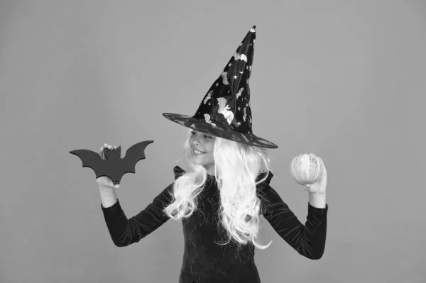 Magisk förtrollning. En liten häxa med vitt hår. Trollkarl eller trollkarl. Halloweenfest. En liten flicka i svart häxhatt. Höstlovet. Häng med och fira. Halloween-attribut. Ett litet barn i häxdräkt — Stockfoto