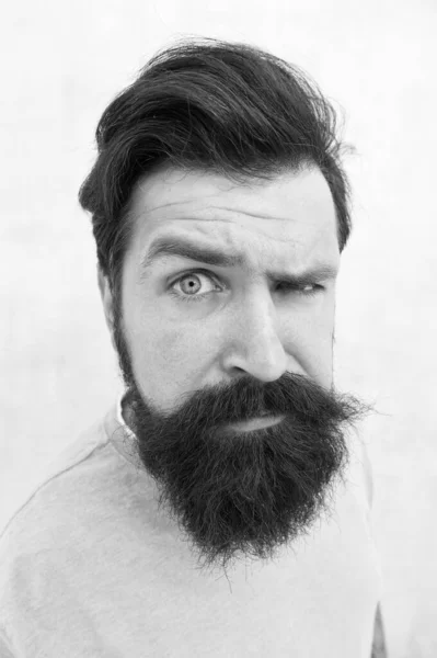 Mirada sospechosa. Percepciones de la belleza masculina. Barba elegante y cuidado del bigote. Cara feliz. Peluquero barba de moda. Un tipo guapo. Concepto masculinidad. Hombre barbudo hipster elegante barba gris fondo —  Fotos de Stock