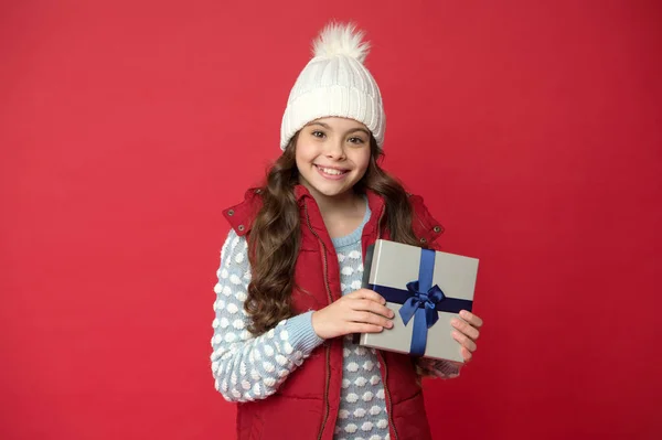 Felicidade verdadeira. fazer coisas agradáveis. garoto feliz em roupas de inverno fundo vermelho. O ano novo está chegando. pequena caixa de presente para criança. infância feliz. presentes de Natal lembranças. prepare-se para férias de inverno — Fotografia de Stock