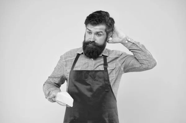 Quoi cuisiner à partir de fromage. Magasin d'alimentation laitière. Achats en ligne. Produit gastronomique. homme barbu perplexe tenir du fromage. techniques de fabrication du fromage. fromager. hipster avec barbe dans tablier de chef — Photo