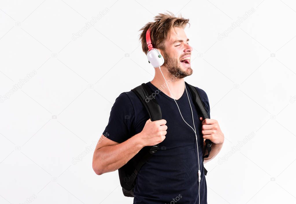 Student handsome guy listening music. Youth music taste. Modern people concept. Man tousled hairstyle wear plastic earphones gadget. Enjoy music everywhere you go. Download music application