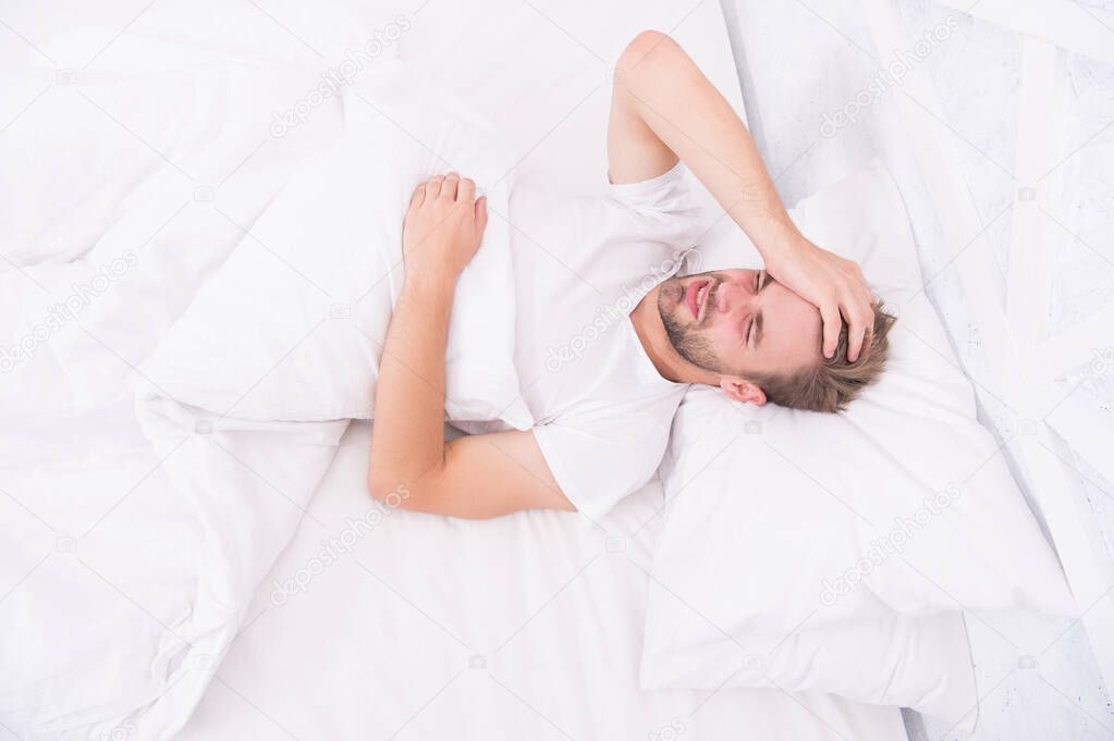 Limit activities in bed. guy had sleepless night. male health concept. Peacefulness concept. tired man sleep in bed. early morning wakeup. man sleep white bedroom. cosy weekend at home. time to relax