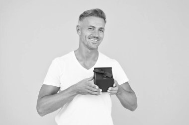 Kalbimi al. Olgun erkek hediye kutusu. Tıraşsız maço adam sarı arka plan. Kalpten gelen bir hediye. Sevgiyle hediye. Doğum günün kutlu olsun. Mutlu yüzlü adam sevgililer gününü kutluyor. Erkekler için eşyalar. Sevgilisi için.