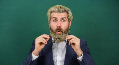 Sınıfta sürprize açık olmak. Şaşırtıcı öğretmen yeşil karatahta. Sakallı adam şaşırmış görünüyor. Şaşırmış ve etkilenmiş öğretmen. Özel ders ve özel ders. Çok şaşırdım.