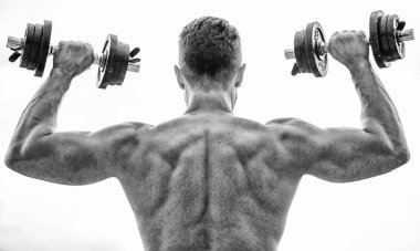 Spor yaşam tarzı. Aptal egzersiz salonu. Kas yığını adam dambıl gibi dikiz aynasıyla egzersiz yapıyor. Acı geçicidir, gurur ise sonsuzdur. Sırtı ve kolları güçlü bir sporcu. Spor malzemeleri. Vücut geliştirme sporu