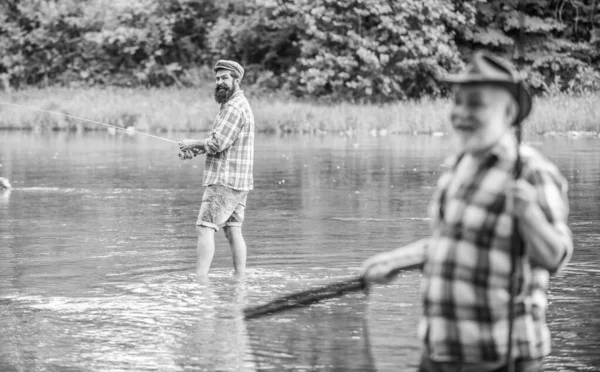 Old friends. family bonding. summer weekend. two fishermen with fishing rods, selective focus. mature man fisher. hobby and sport activity. son and father fishing. male friendship — Stock Photo, Image