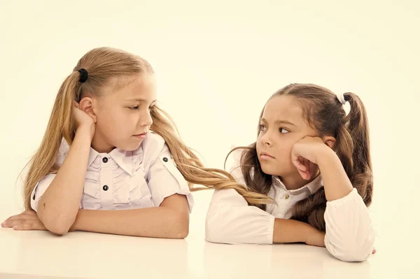 Adorables colegialas. De vuelta a la escuela. Concepto educativo. Hermosas chicas mejores amigas. Estilo formal. Feliz infancia. Las colegialas se sientan en el escritorio fondo blanco. Colegialas amigos emocionales — Foto de Stock