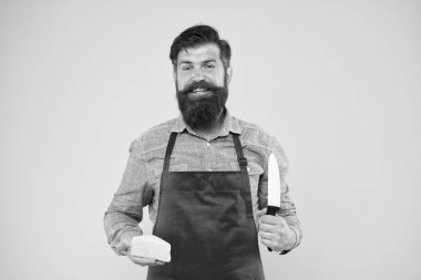 Yemek için hazırım. Peynir yapma konsepti. Peynir üreticisinin kendi işi. Şef önlüklü sakallı hippi. Süt ürünleri dükkanı. Peynir festivali. Diyet ve beslenme. Mutlu sakallı adam peyniri bıçakla kesti.