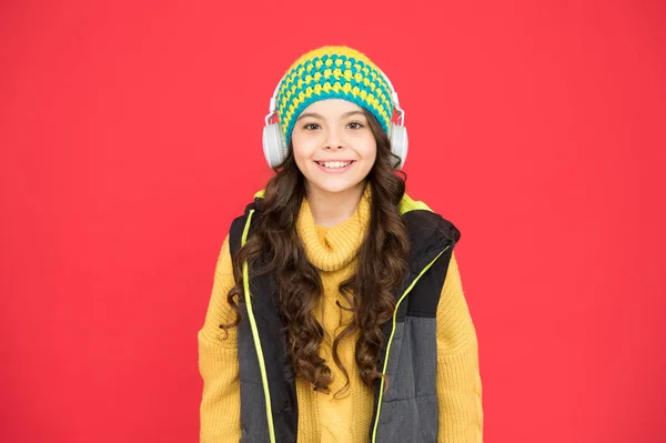 Musica per l'inverno. Bambino felice ascolta la musica. La bambina indossa le cuffie suonando musica. Divertimento e intrattenimento. Nuove tecnologie. La vita moderna. Attività musicali all'aperto per bambini — Foto Stock